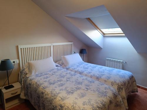 una camera con un letto con una coperta blu e bianca di Apartamentos Astilleros a Candás