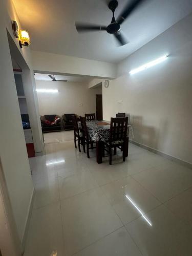 uma sala de estar com uma mesa e cadeiras e um sofá em Garden Club em Mangalore