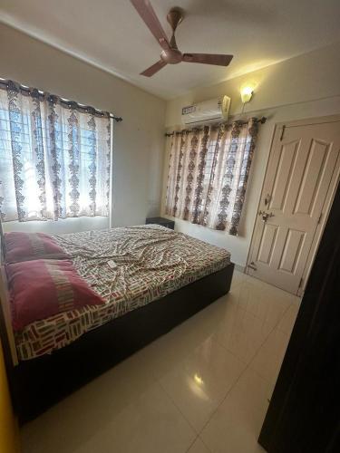 um quarto com uma cama e uma ventoinha de tecto em Garden Club em Mangalore