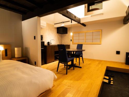 a bedroom with a bed and a table and chairs at Auberge Homachi Mikuniminato in Sakai