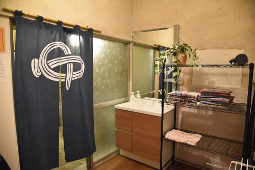 a bathroom with a shower curtain and a sink at 内竈ひなた庵 in Kamegawa