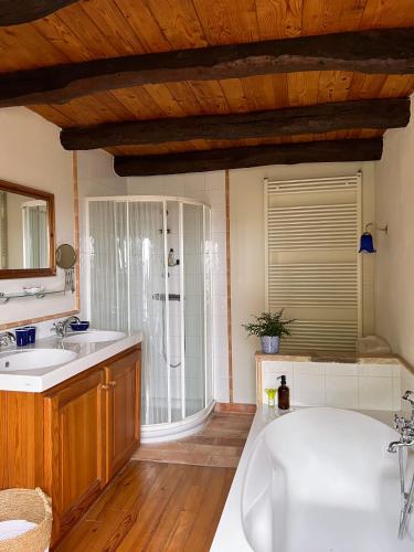 une salle de bain avec deux lavabos et une baignoire dans l'établissement Les Hauts de Broze, à Broze