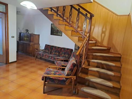 eine Treppe in einem Wohnzimmer mit Sofa in der Unterkunft casetta in montagna in Mocenigo