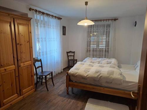 um quarto com uma cama e duas cadeiras em casetta in montagna em Mocenigo
