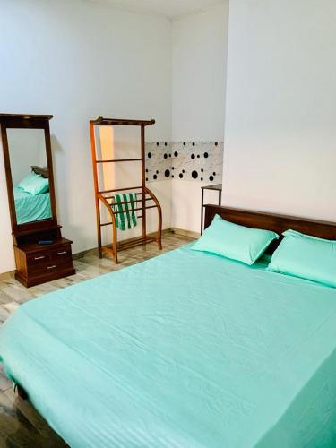 une chambre avec un lit, un miroir et une chaise dans l'établissement Lemon Stay, à Negombo