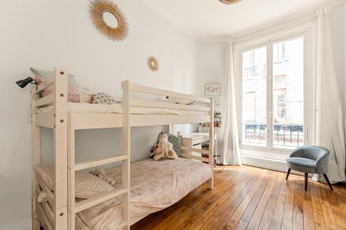 une chambre avec deux lits superposés et une fenêtre dans l'établissement École Militaire, à Paris