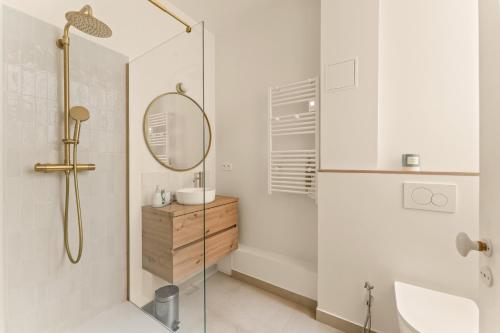 une salle de bain avec une douche, un lavabo et un miroir dans l'établissement École Militaire, à Paris