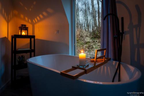 uma vela numa banheira com uma janela em Bunkier House 