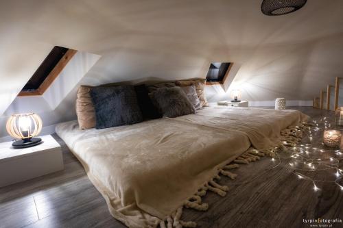 a bedroom with a large bed in a attic at Bunkier House in Niedźwiada