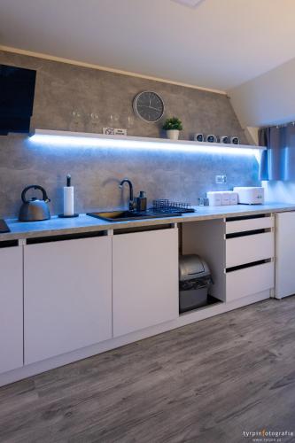 a kitchen with white cabinets and a sink at Bunkier House in Niedźwiada