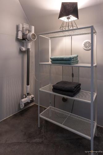 a room with a shelf with towels and a light at Bunkier House in Niedźwiada