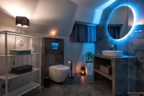 a bathroom with a sink and a toilet and a mirror at Bunkier House in Niedźwiada