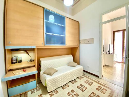 a bedroom with a bed and a desk and a window at Le Case di Anan, Castellammare del Golfo in Castellammare del Golfo