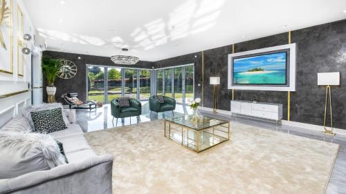 a living room with a couch and a glass table at Luxury 10,000 Sq Ft 7-bed Mansion With Indoor Pool in Sidcup