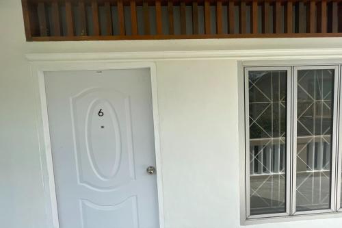 a white door and a window in a room at Andaman Residence in Thalang