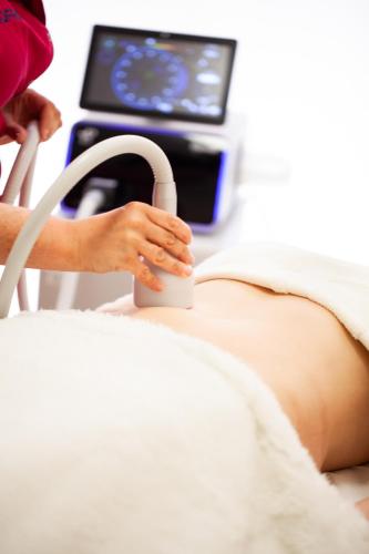 a pregnant woman in a hospital bed holding a hula at Instytut Zdrowia Sofra FIT & SPA in Mielno