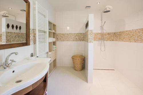 a white bathroom with a sink and a shower at B&B Louisehoeve in Linschoten