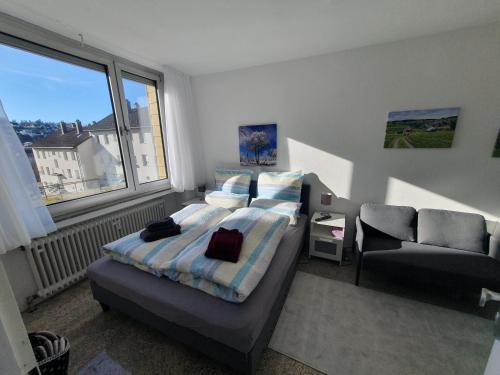 1 dormitorio con 1 cama, 1 silla y 1 ventana en 1-Zimmer-Wohnung-EG Fewo 2 Rupertsberg, en St. Georgen im Schwarzwald