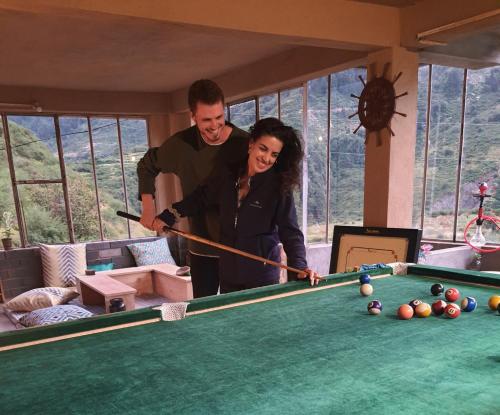 a man and woman standing next to a pool table at Dhauladhar Woodhouse in Malotha