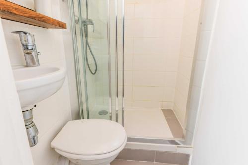 een badkamer met een douche, een toilet en een wastafel bij Cozy Parisian Retreat in the Heart of the City in Parijs