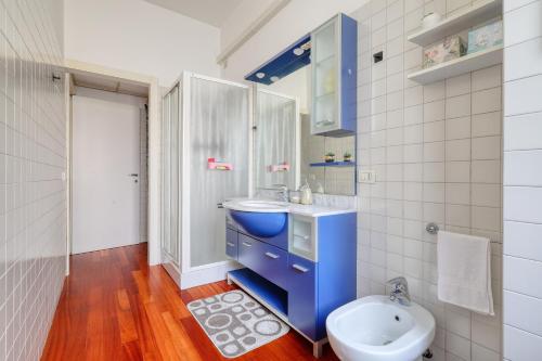 bagno con lavandino blu e servizi igienici di Ample Apartment with private parking a Milano