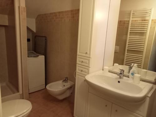 een witte badkamer met een wastafel en een toilet bij Casa Pascal in La Salle
