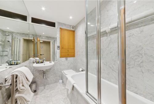 a bathroom with a tub and a sink at Nell Gwynn Chelsea Accommodation in London