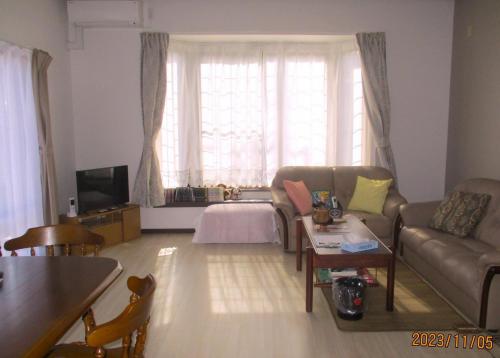 sala de estar con sofá y mesa en Private inn “Come! Akae House” - Vacation STAY 61227v, en Toyama