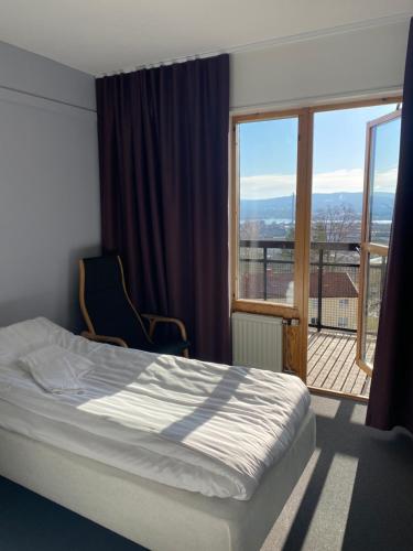 ein Schlafzimmer mit einem Bett und einem großen Fenster in der Unterkunft Svf Hotell & Konferens in Jönköping