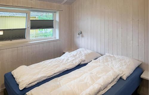 ein unmaskiertes Bett in einem Zimmer mit Fenster in der Unterkunft Schmugglerstieg 7 - Dorf 6 in Travemünde