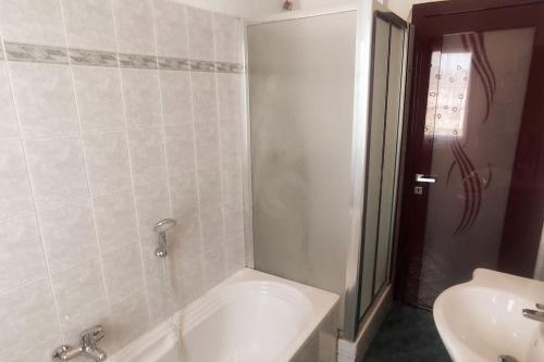 a bathroom with a white tub and a sink at Appartamento a Melegnano-Vizzolo in Dresano
