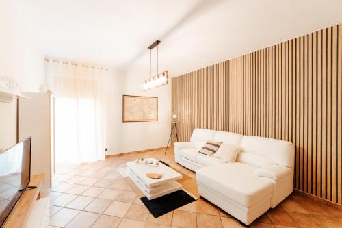 uma sala de estar com um sofá branco e uma televisão em CR32 TOURIST ACCOMODATION em Civitavecchia