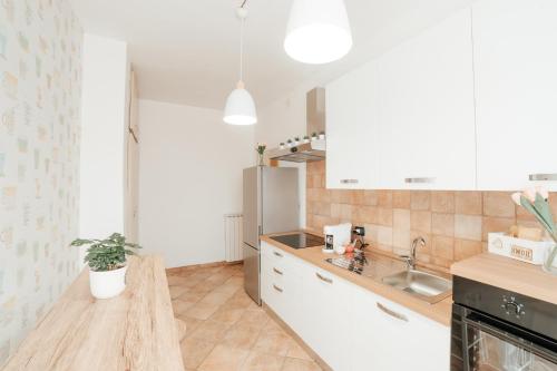 uma cozinha com armários brancos e um lavatório em CR32 TOURIST ACCOMODATION em Civitavecchia