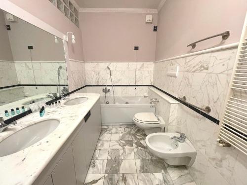 a bathroom with two sinks and a toilet and a tub at Best View Boutique Apartments in Bergamo