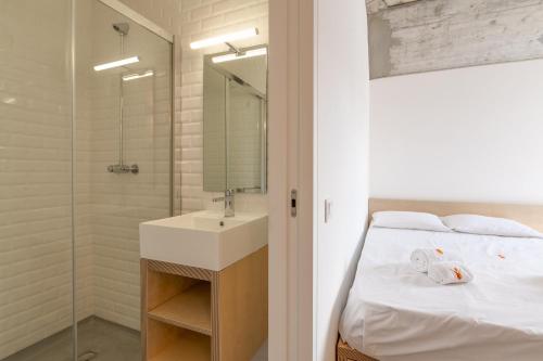 a bathroom with a bed and a sink and a shower at StudentVille Central in Lisbon