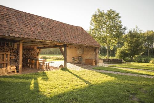 a barn with a table and chairs in a yard at B&B Louisehoeve in Linschoten