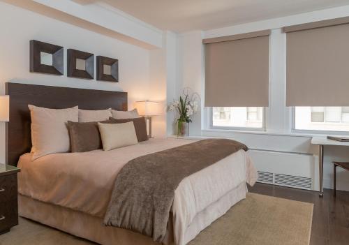 a bedroom with a large bed and two windows at Lombardy Hotel in New York