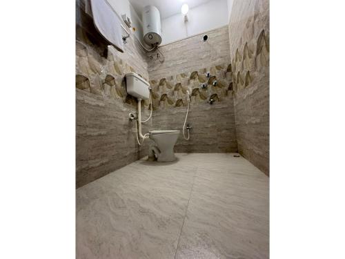 a bathroom with a toilet in a stone wall at Hotel Nalanda Inn Bihar in Nalanda