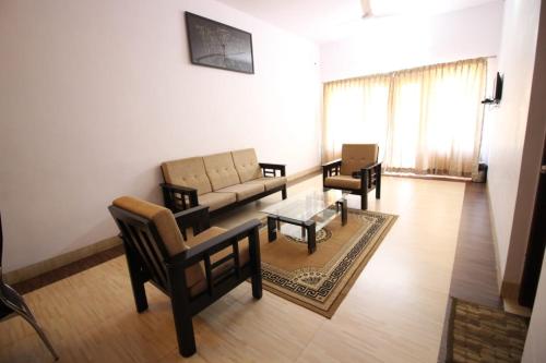 a living room with a couch and chairs and a table at Mount n Mist in Ooty