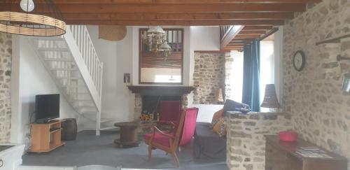 - un salon avec une cheminée et un escalier dans l'établissement Maison en pierres à 1200m de la mer, à Agon-Coutainville