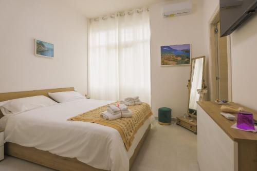 ein Schlafzimmer mit einem Bett mit zwei Handtüchern darauf in der Unterkunft BarbyB B&B in Salerno