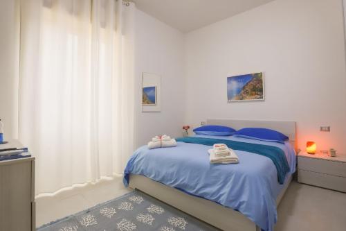 a bedroom with a bed with blue sheets and blue pillows at BarbyB B&B in Salerno