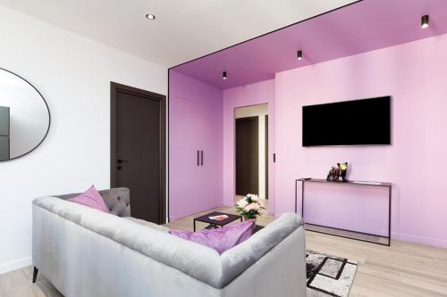 - un salon avec des murs violets et un canapé dans l'établissement Somptueux 4 pièces Foch - Centre Cannes et proche Palais des Festivals, à Cannes