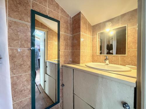 une salle de bain avec un lavabo et un miroir dans l'établissement OASIS DE VERDURE, à Laouque