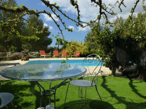 - une table et des chaises dans une cour avec une piscine dans l'établissement OASIS DE VERDURE, à Laouque