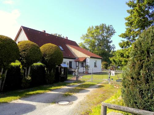 ein Haus mit einem Zaun davor in der Unterkunft Bungalow und Ferienwohnung auf Rügen in Kluis
