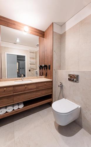 a bathroom with a tub and a toilet and a sink at Instytut Zdrowia Sofra FIT & SPA in Mielno