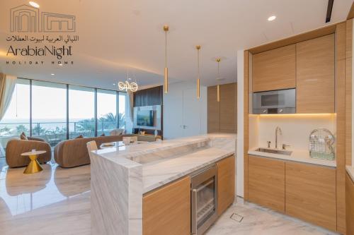 a kitchen with a large sink and a living room at Arabian Nights - Seaside Splendor Apartment at Atlantis The Royal in Dubai