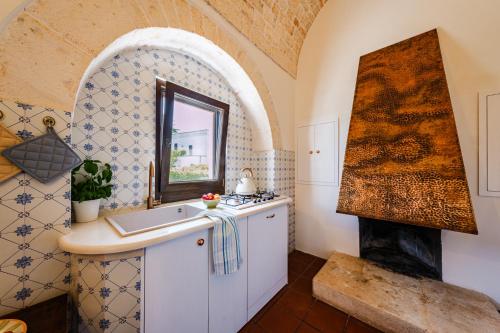 kuchnia ze zlewem i kuchenką w pokoju w obiekcie HelloApulia Masseria Don Sisto - 10 guests w Alberobello