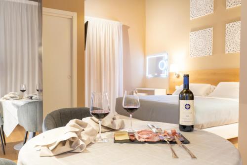 a hotel room with a table with two glasses of wine at GG8 Hotel & Suite SPA in Gualdo Tadino